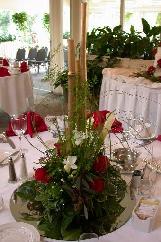 red roses, dendrobium orchids, freesia, and greens with gold bamboo make this an outstanding centerpiece.
