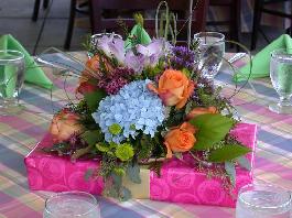 blue hydrangia, orange roses, lavender freesia purple statis green viburnium created by our party planners